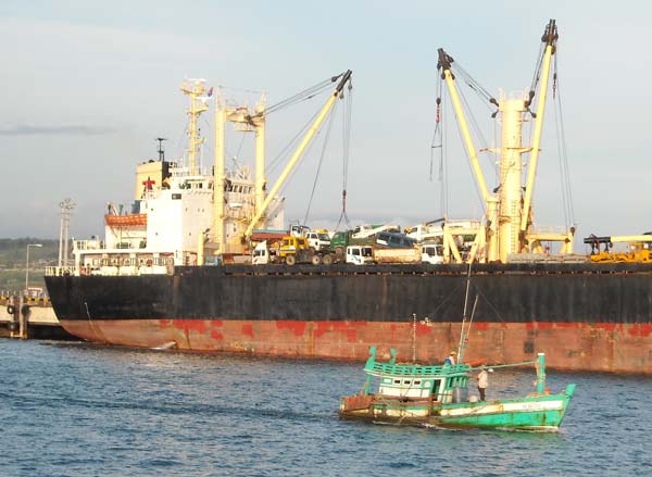 a ship in sihanoukville, cambodia unloading used cars from korea.